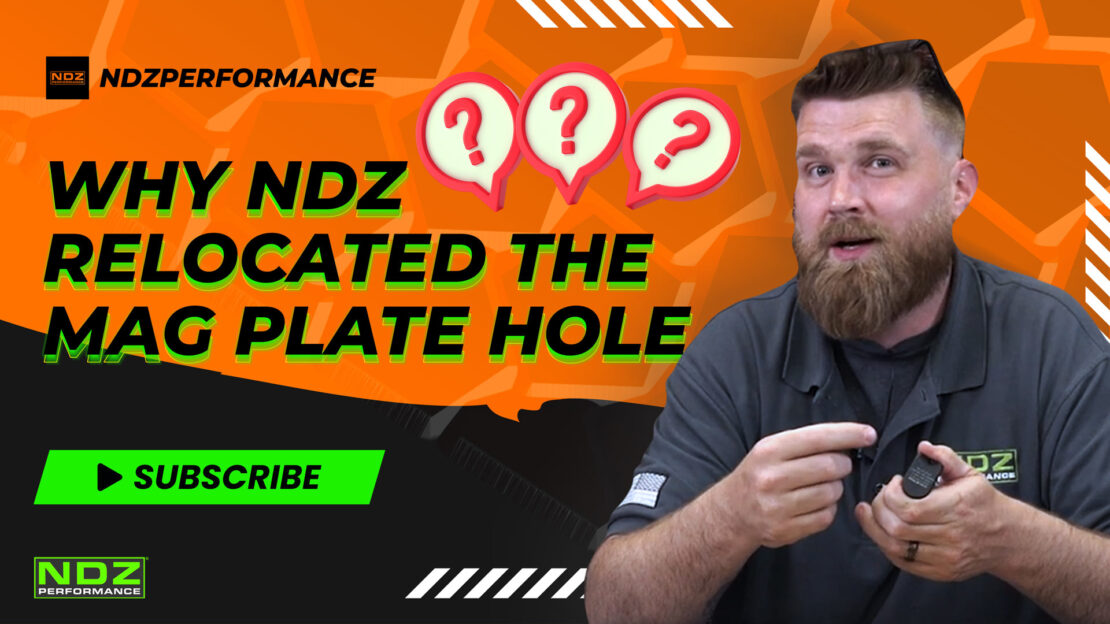 Video thumbnail for NDZ Performance titled 'Why NDZ Relocated the Mag Plate Hole.' The image features Justin, a man with a beard, holding a firearm part, set against an orange background with question marks and the NDZ Performance logo. A subscribe button is also visible.