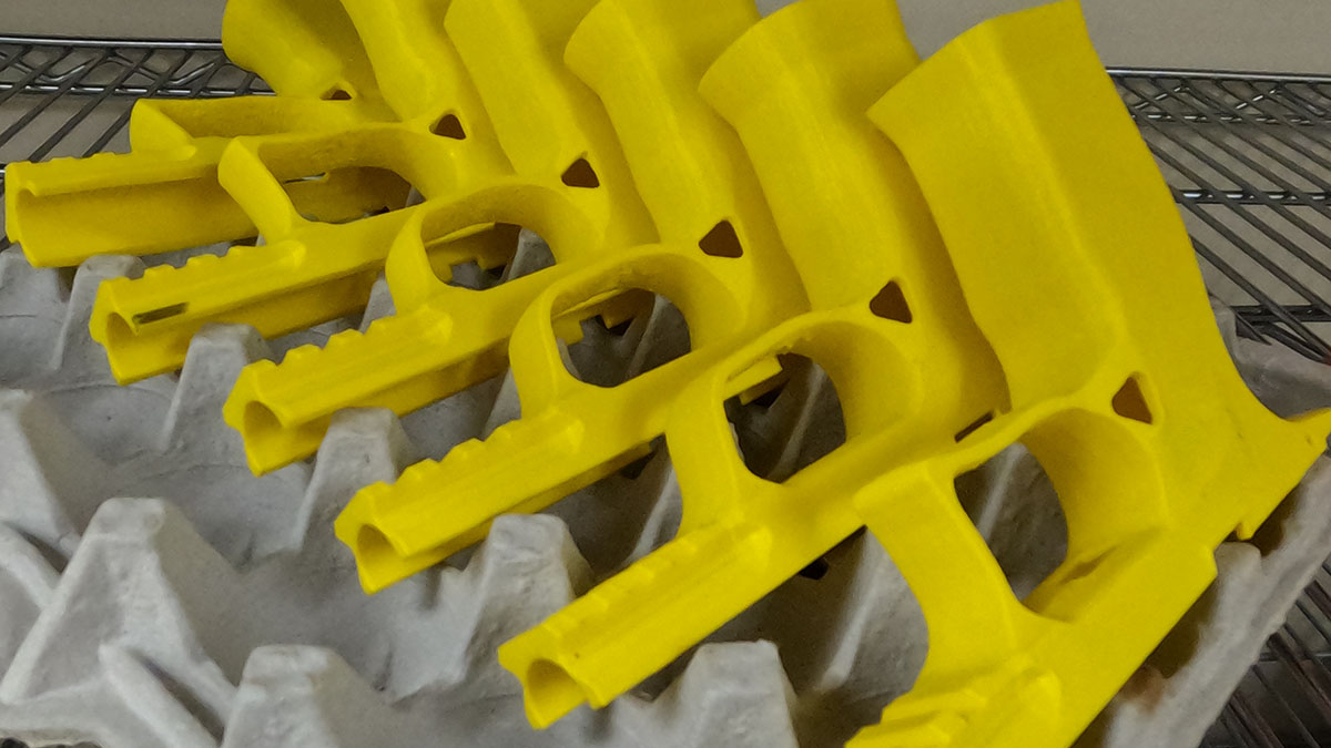 Yellow 3D printed prototype parts on a tray in the NDZ shop