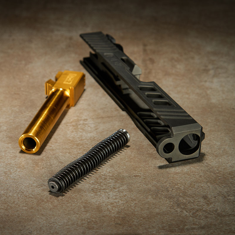 Glock 19 Gen 3 slide with a gold barrel and guide rod