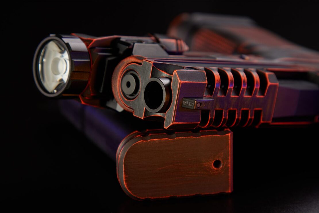 Front view of the build lying on its side, showing the A.R.E.S. slide and barrel at the muzzle beside the Holosun light.