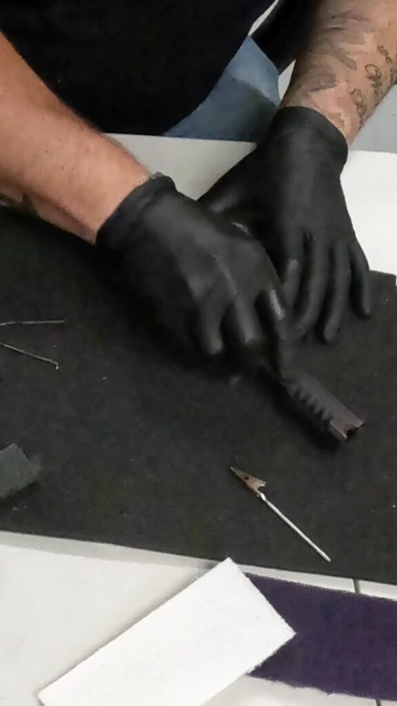 Distressing the top coat on the A.R.E.S. slide by hand.